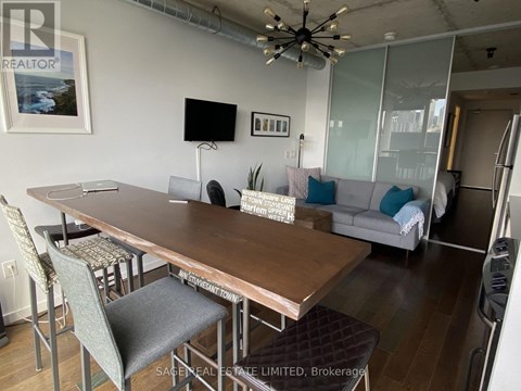 A dining room with a wooden table and chairs.
