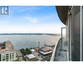 A view from a high-rise building looking out over a waterfront with boats and industrial buildings.