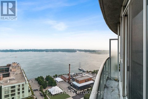 A view from a high-rise building looking out over a waterfront with boats and industrial buildings.