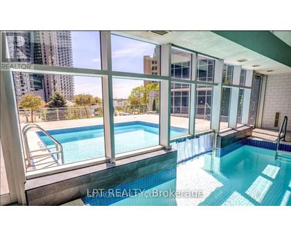 A pool inside a building with a view of the city.