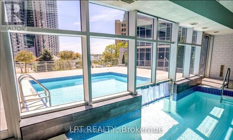 A pool inside a building with a view of the city.