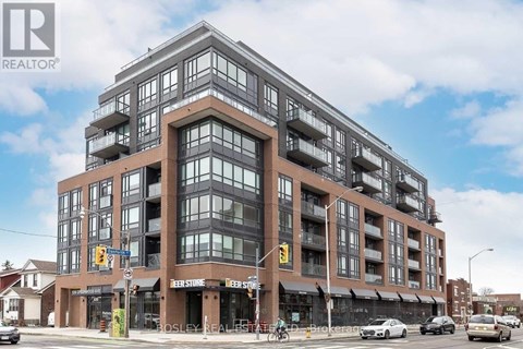 A large multi-story building with a glass facade and a brown exterior.