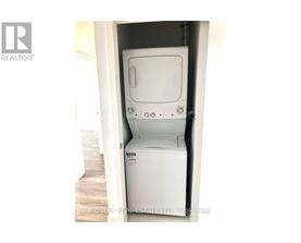 A white dryer is in a small space.