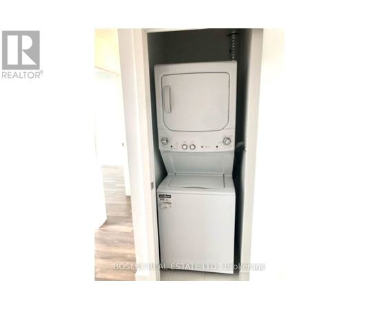 A white dryer is in a small space.