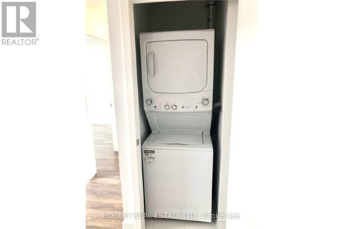 A white dryer is in a small space.