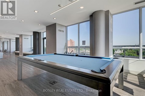 A pool table in a room with a view of the city.