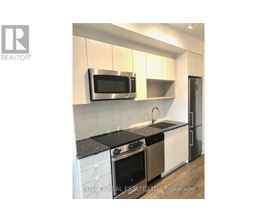 A modern kitchen with a stainless steel microwave above the stove.