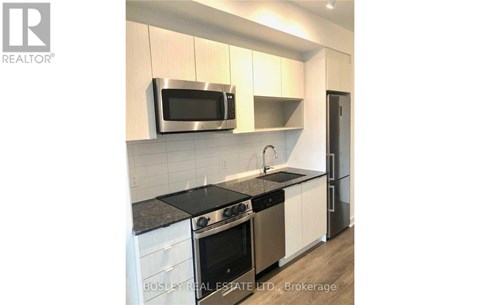 A modern kitchen with a stainless steel microwave above the stove.