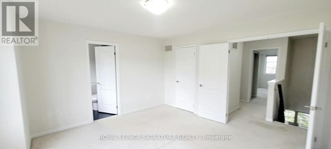 A white room with a doorway leading to another room.