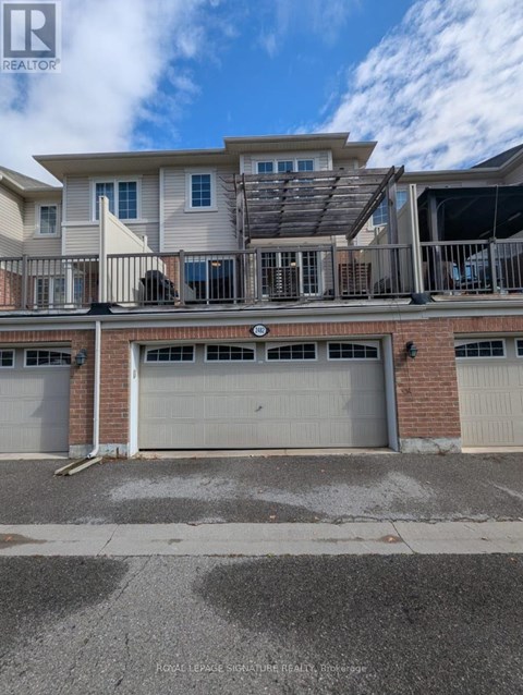 A two-story residential building with a garage door in the foreground.