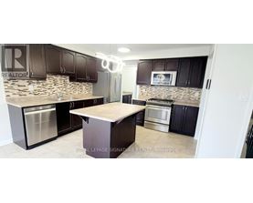 A kitchen with a stone backsplash and stainless steel appliances.
