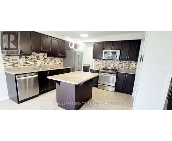 A kitchen with a stone backsplash and stainless steel appliances.