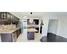A kitchen with black cabinets and a stone backsplash.