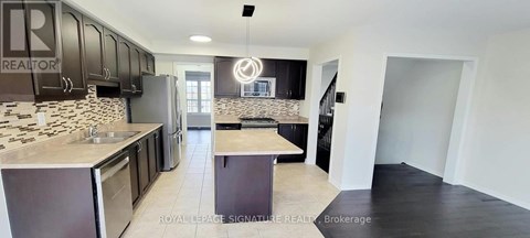 A kitchen with black cabinets and a stone backsplash.
