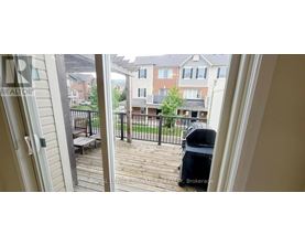 A balcony with a table and chairs overlooks a residential area.