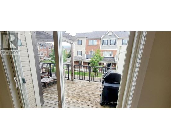 A balcony with a table and chairs overlooks a residential area.