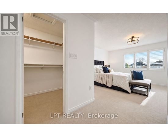 A bedroom with a bed and a window with blinds.