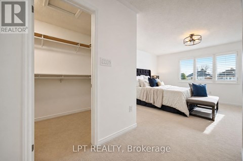 A bedroom with a bed and a window with blinds.