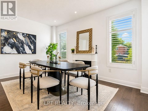 A dining room with a black table and chairs.