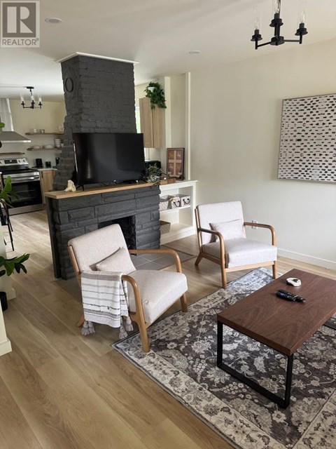 A living room with a fireplace and two chairs.