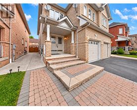 A large house with a brick driveway and a garage.