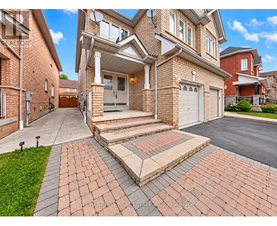A large house with a brick driveway and a garage.