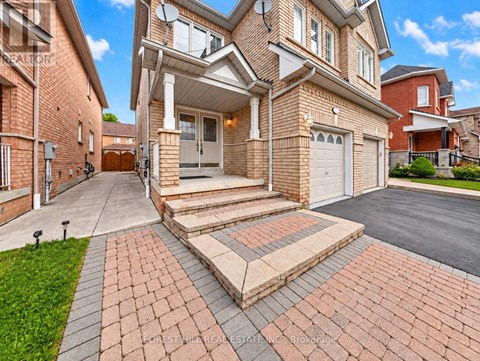 A large house with a brick driveway and a garage.