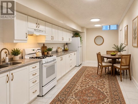 A kitchen with white cabinets and a rug on the floor.