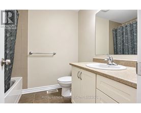 A bathroom with a toilet, sink, and shower.