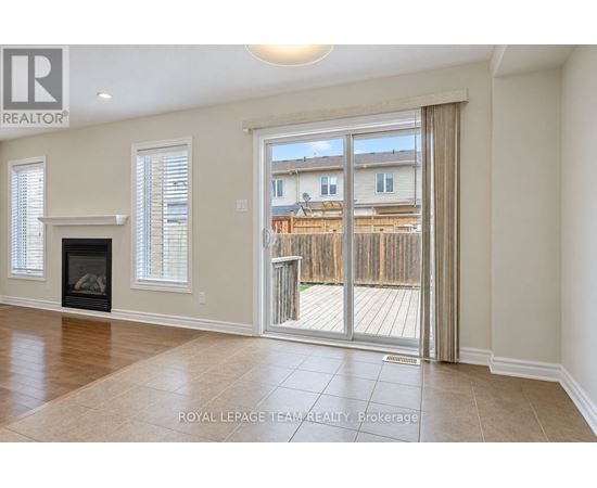 A spacious living room with a fireplace and sliding glass doors leading to a deck.