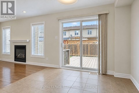 A spacious living room with a fireplace and sliding glass doors leading to a deck.