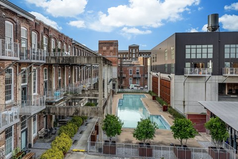 A view of a courtyard with a pool and a fence.