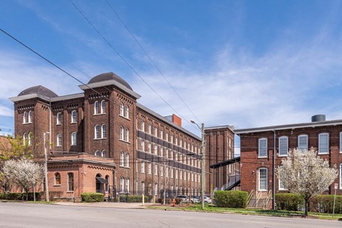 A large red brick building with a tower and a smaller one next to it.