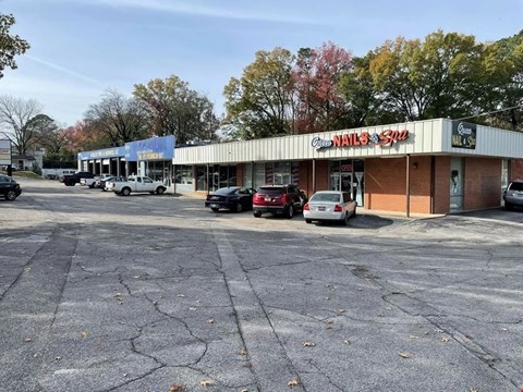 A parking lot in front of a nail and spa store.