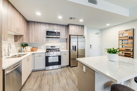 A modern kitchen with a stainless steel refrigerator and oven.