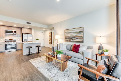 A modern living room with a grey sofa and a wooden coffee table.