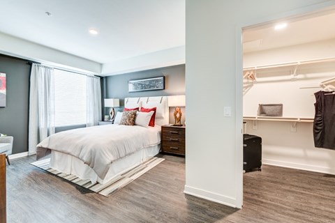 A bedroom with a large bed and a wooden floor.