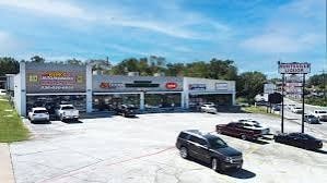 A parking lot with cars and a building in the background.