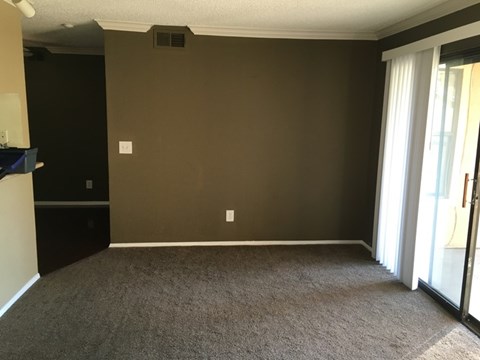 A room with a carpeted floor and a sliding glass door.