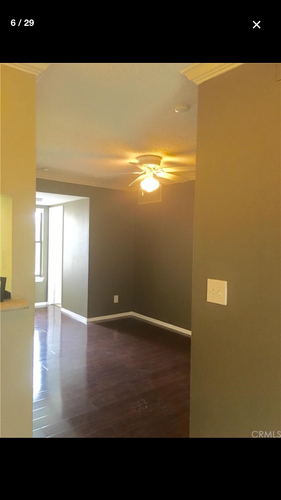 A room with a ceiling fan and a doorway leading to another room.