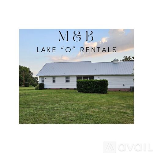 A white building with a sign that says M&B Lake "O" Rentals.