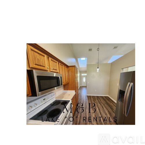 A kitchen with wooden cabinets and a white stove top oven.