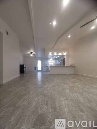 A spacious room with a grey floor and white walls.
