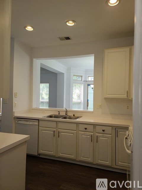 A kitchen with white cabinets and a sink.