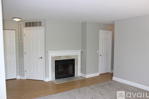 A living room with a fireplace and two doors.