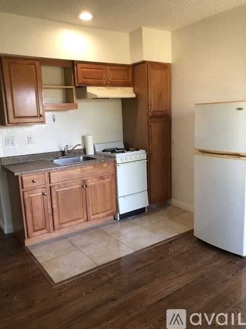 A kitchen with wooden cabinets and a white refrigerator.