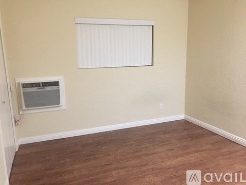 A room with a window and a wall socket.
