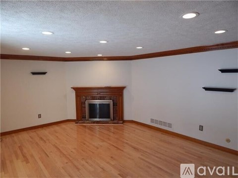 A living room with a fireplace and wooden floors.