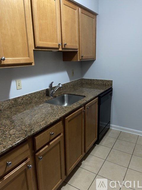 A kitchen with granite countertops and wooden cabinets.