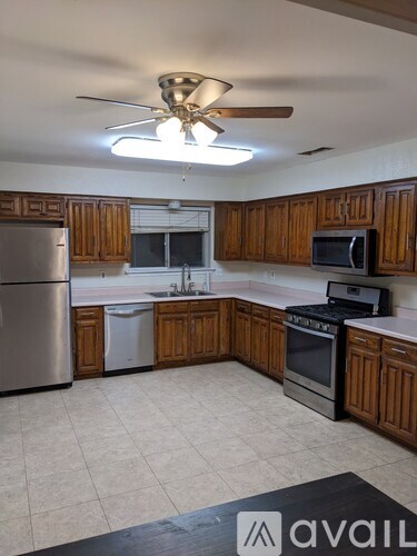 A kitchen with wooden cabinets and a refrigerator.